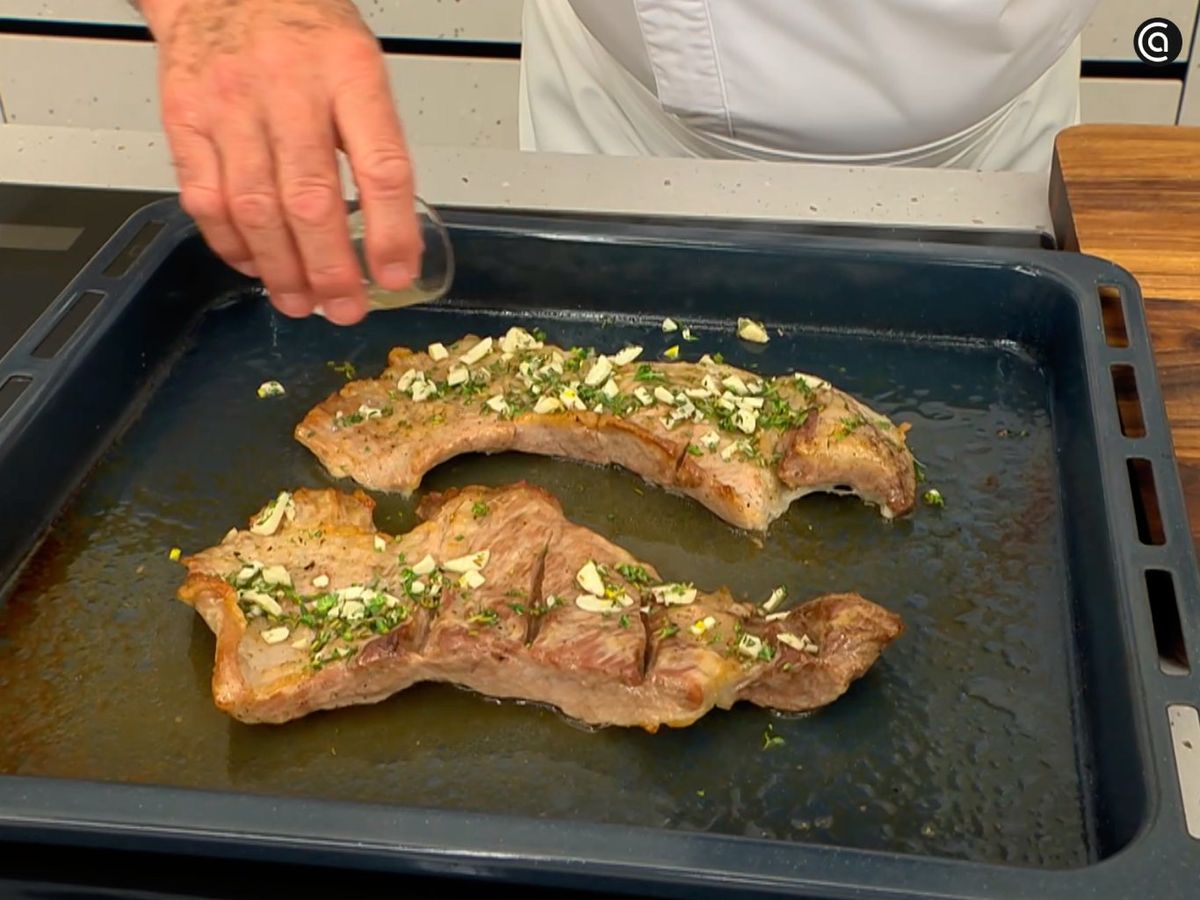 Añade ajo picado, tomillo y vinagre sobre el secreto y hornéalo de nuevo