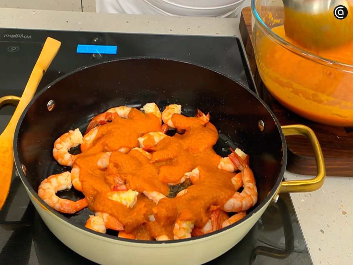 Saltea los langostinos, añade la salsa americana y mezcla bien