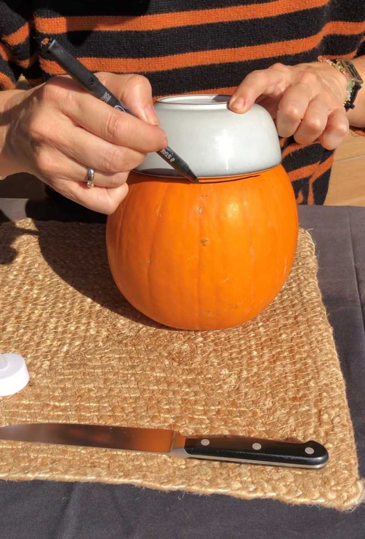 Dibujar la tapa de la calabaza de Halloween con un cuenco del revés.