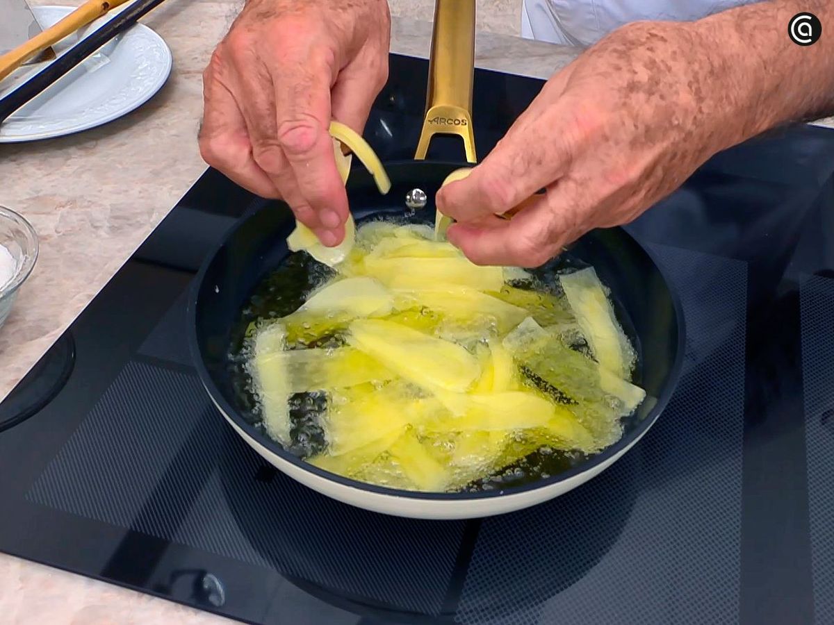 Freír las patatas para el pollo entomatado