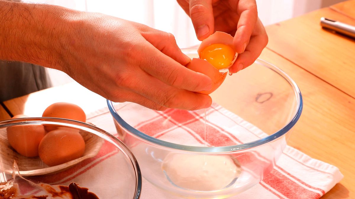 Incorporar las yemas al chocolate templado, clave para una textura suave en la mousse