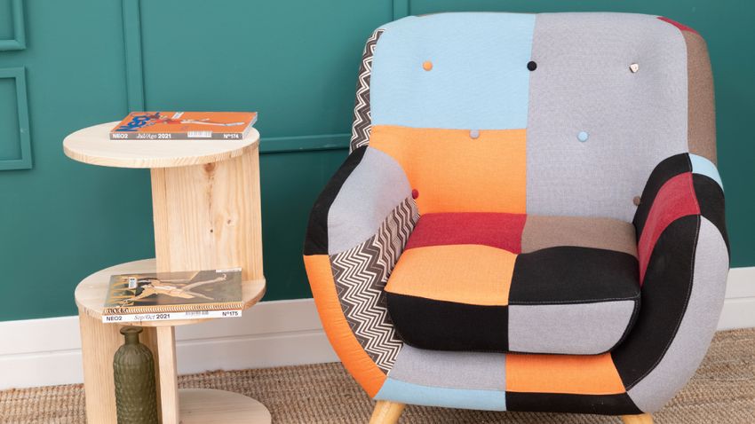 a mesa auxiliar original ya en su rincón final, perfecta como apoyo decorativo junto al sillón.