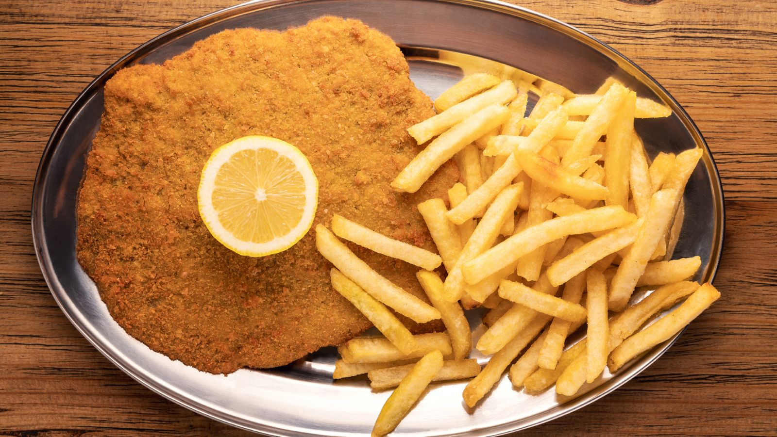 La milanesa perfecta, servida con patatas fritas y un toque de limón: un plato icónico de la cocina argentina que también brilla en la serie Nada.