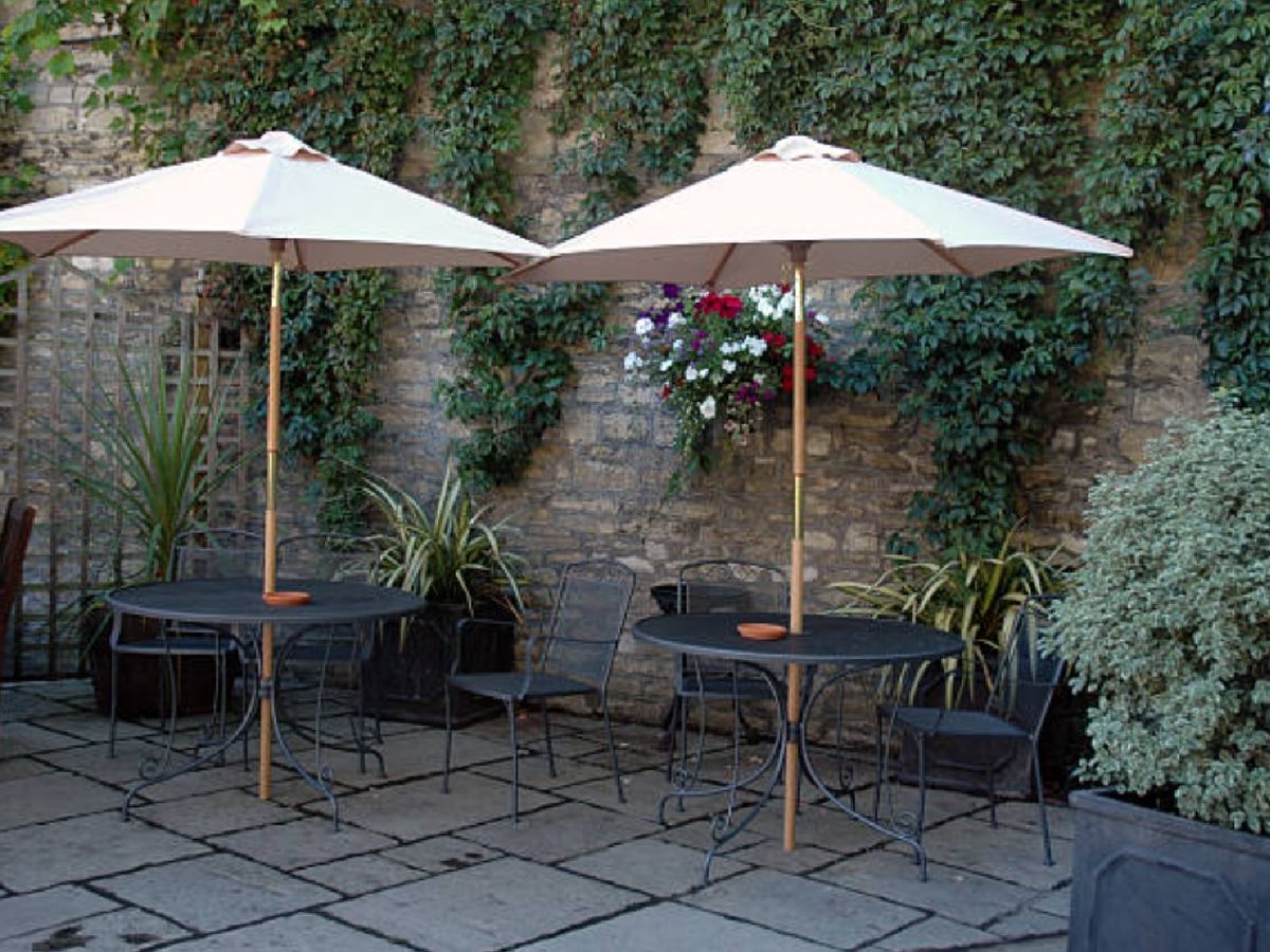 Mesa de hierro con sombrilla, ideal para zonas sin sombra