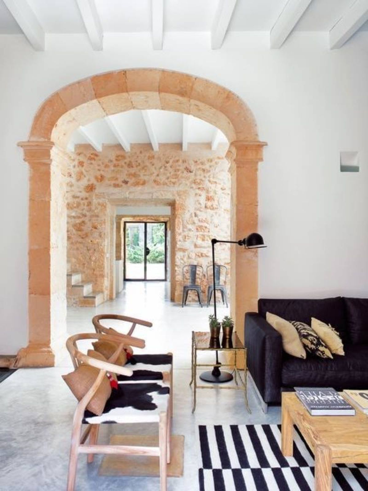 Casa de estilo mediterráneo con arco de piedra natural.