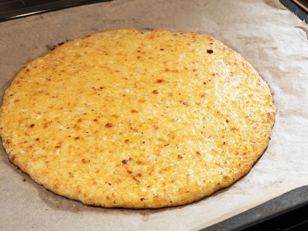 Hornea la masa de pizza de coliflor durante 20 minutos o hasta que veas dorados los bordes