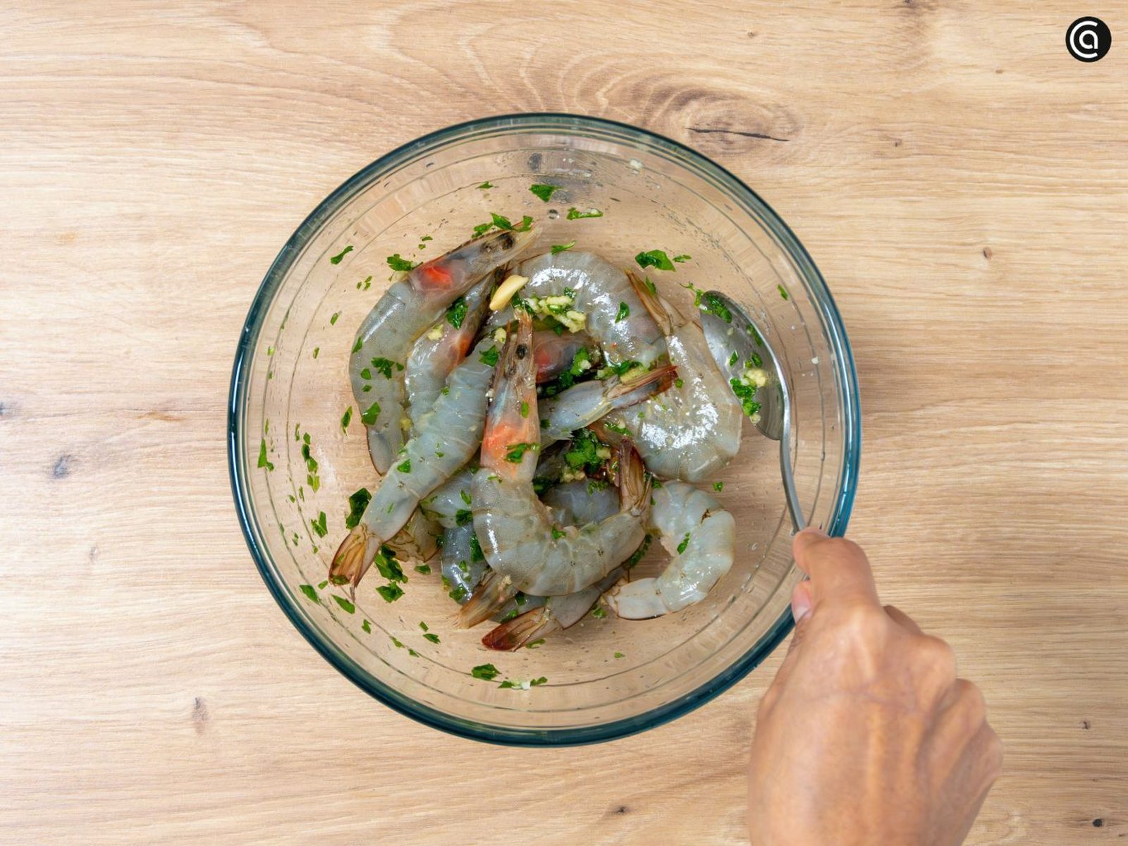Pon los langostinos en el bol y cúbrelos con el majado de ajo y perejil