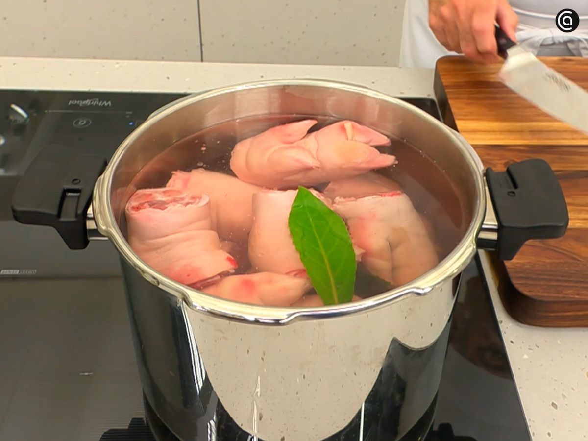 Cocina las manitas de cerdo con laurel, perejil, ajos pelados y cebolla picada