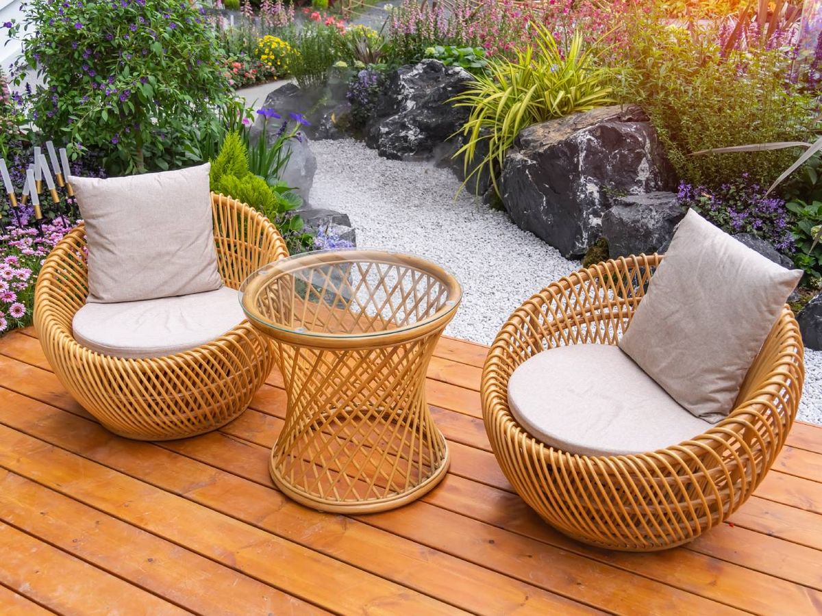 Jardín con muebles de exterior de mimbre.