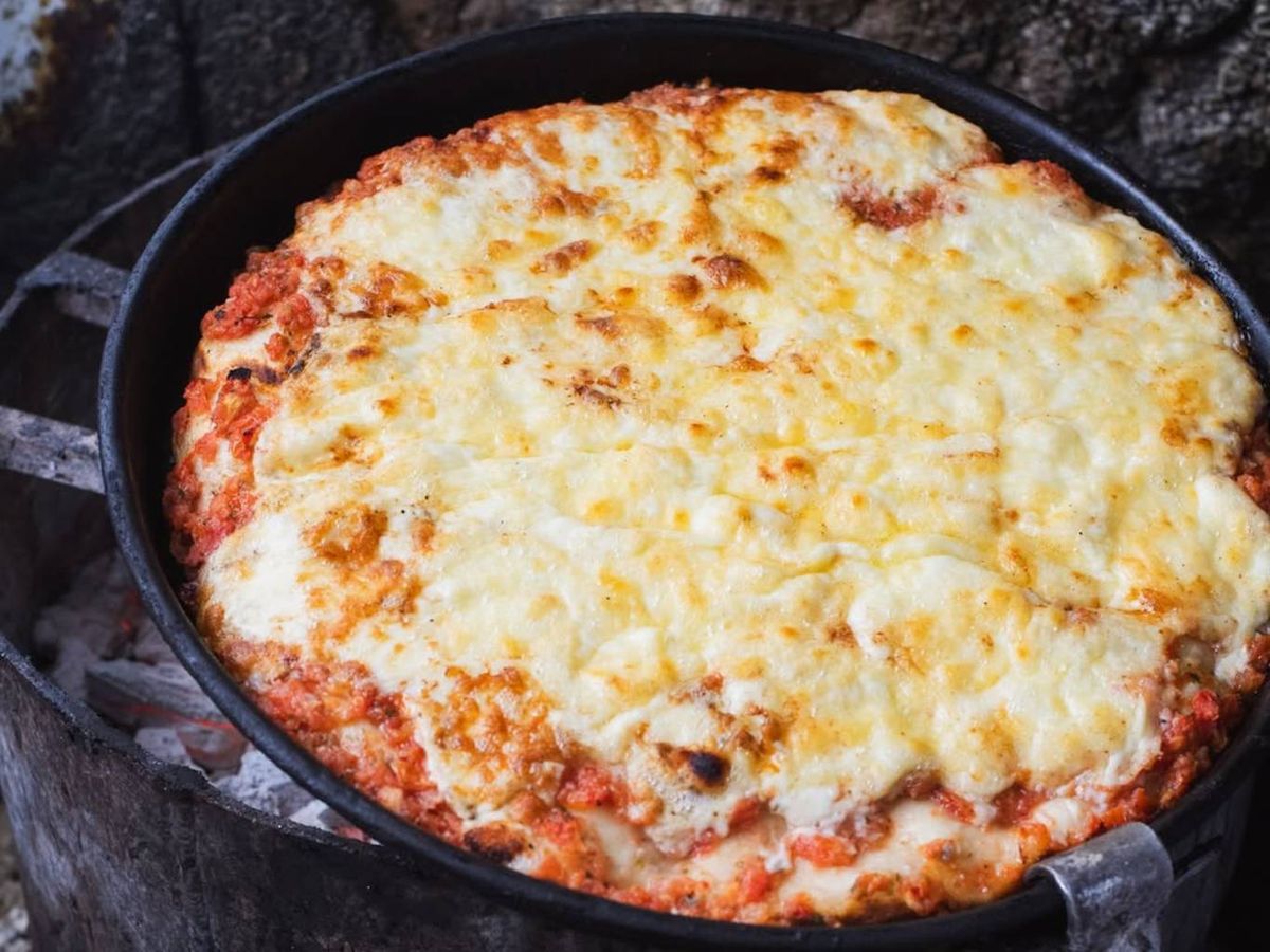 Pizza al molde argentina recién horneada con una generosa capa de queso.