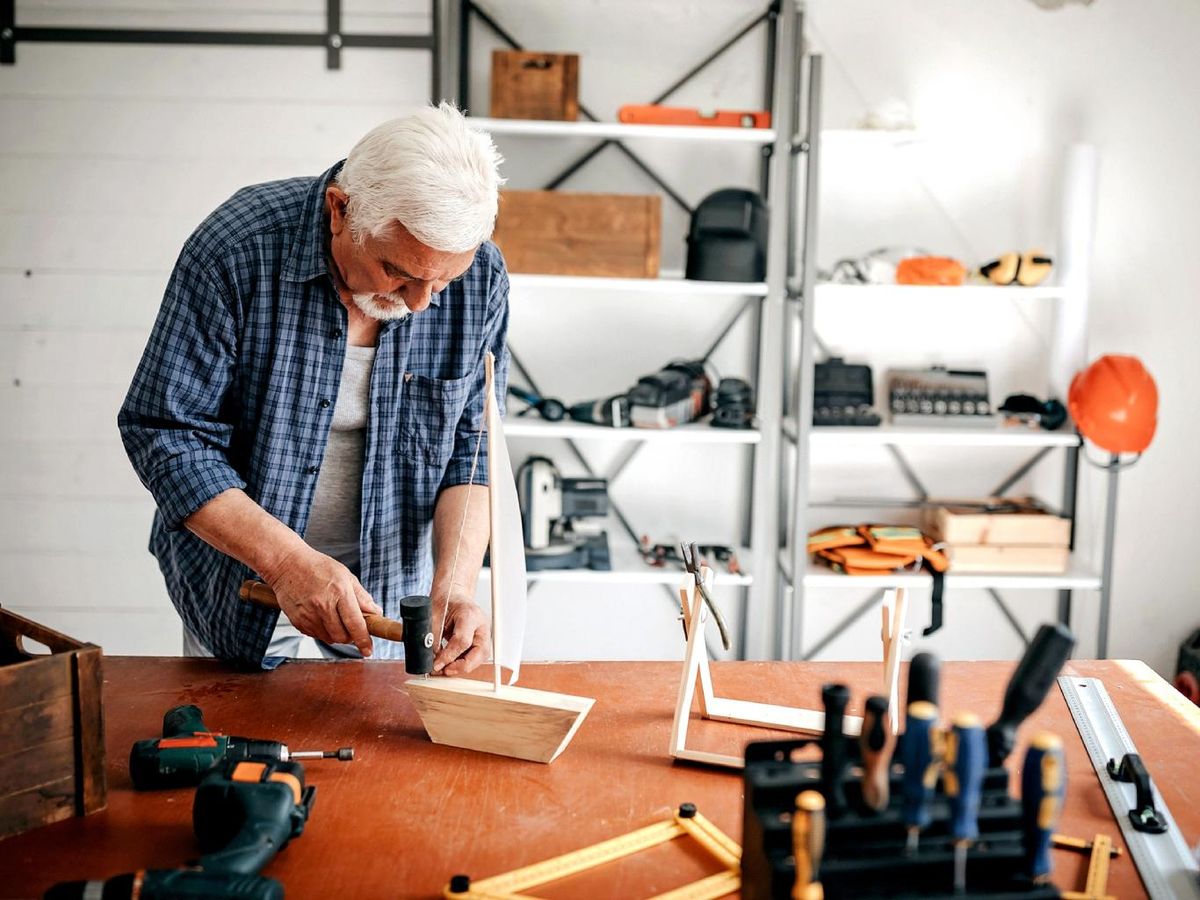 Hombre en un garaje con estanterías metálicas.