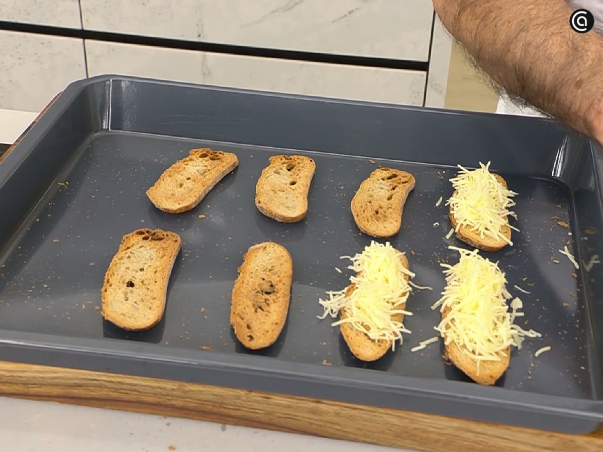 Añade queso para gratinar a las tostadas de pan para servirlas sobre la sopa de cebolla