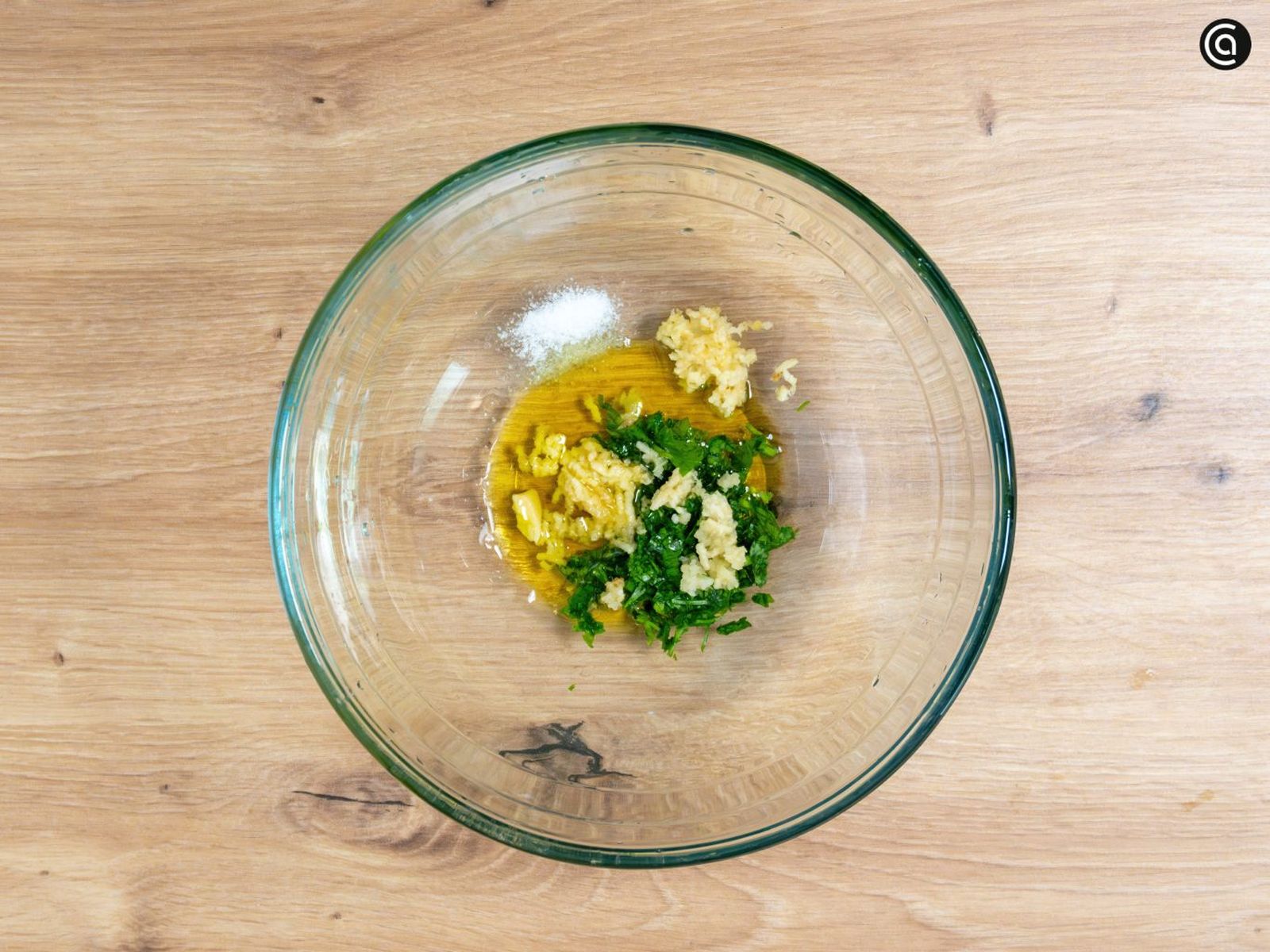 Pica el ajo, añádelo al aceite y mezcla con el perejil picado