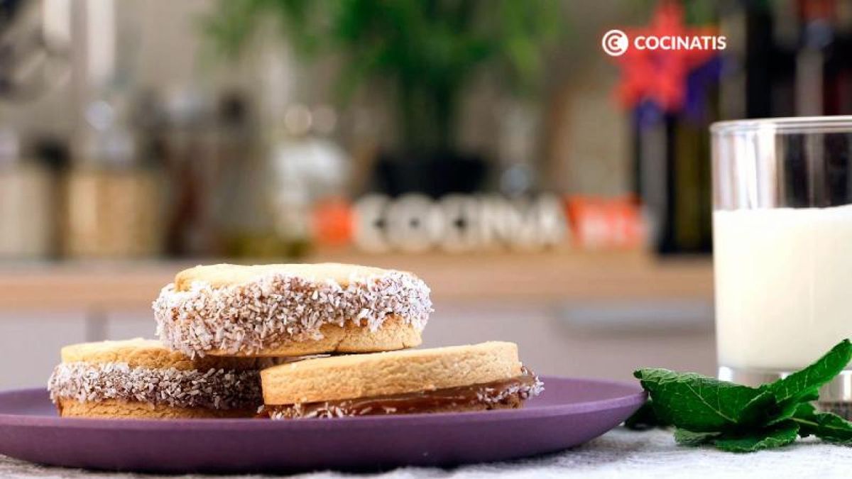 Sirve los alfajores rellenos de dulce de leche con coco rallado