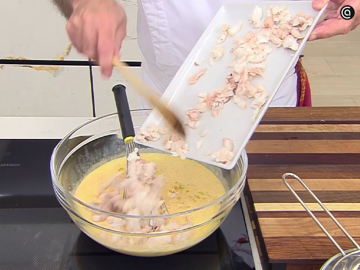 Añade el cabracho desmenuzado a la mezcla de huevos, nata, salsa de tomate y puerros