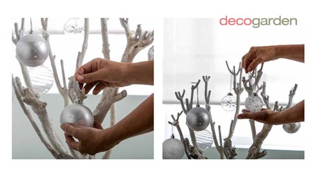 Adornar el árbol de Navidad con ramas con bolas plateadas, blancas y de cristal.