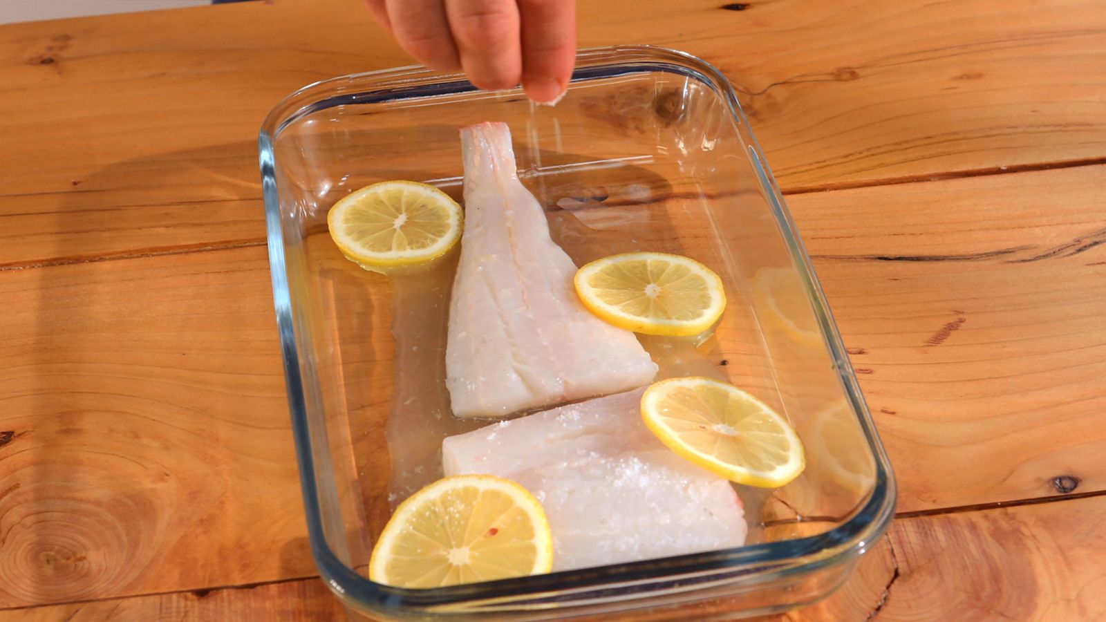 Añade a una bandeja apta para horno la merluza, unas rodajas de limón y el zumo del limón Wrap de pescado con salsa de yogur Paso 1