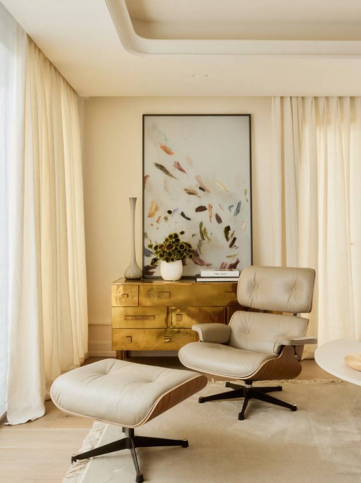 Cómoda de latón vintage y sillón chaise longe del salón de la casa de Tamara Falcó..