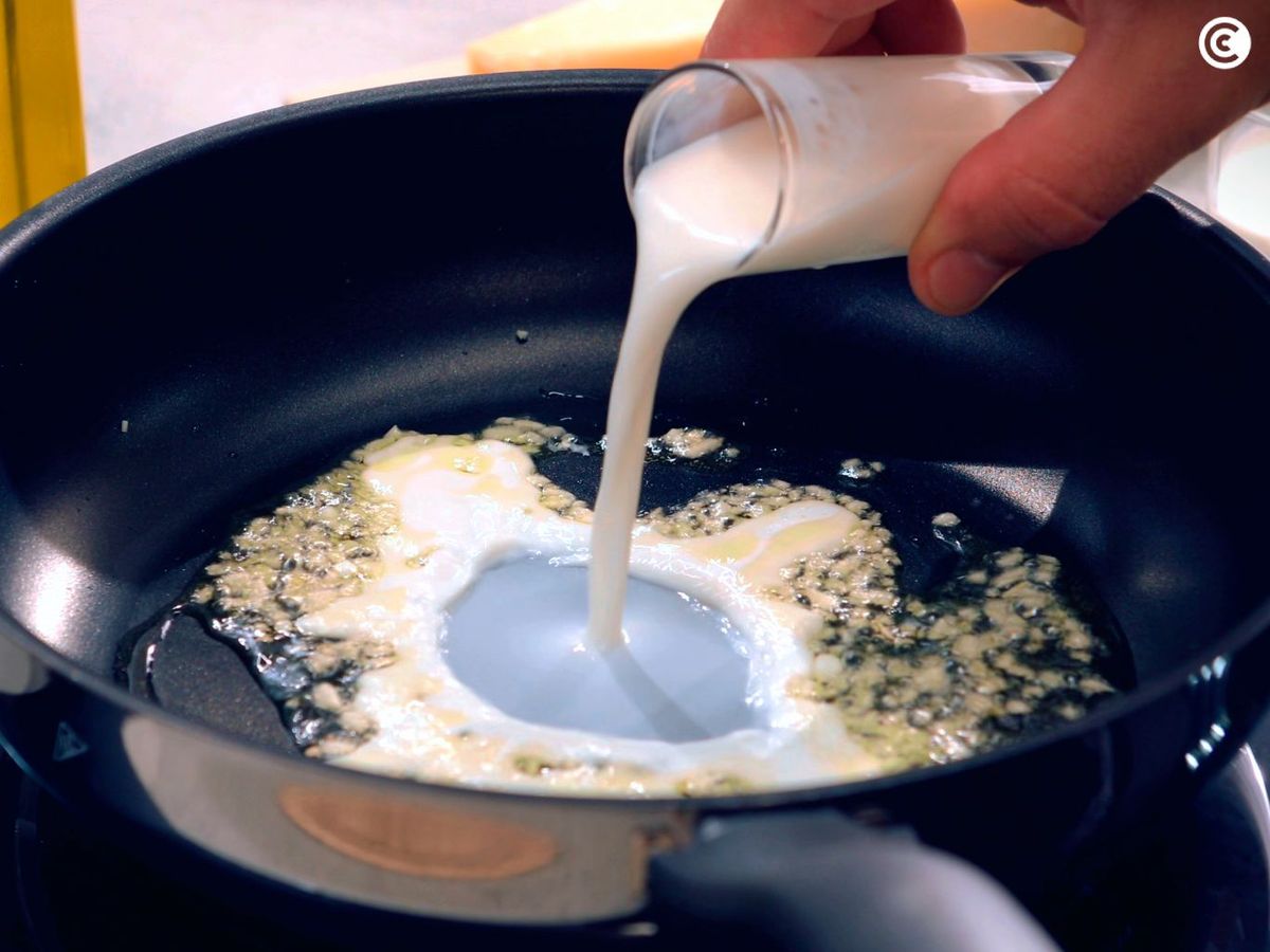 Añade ajo, nata y leche para comenzar a hacer la salsa Alfredo