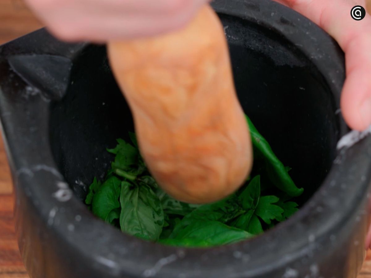 En un mortero, machaca las hojas de albahaca con aceite