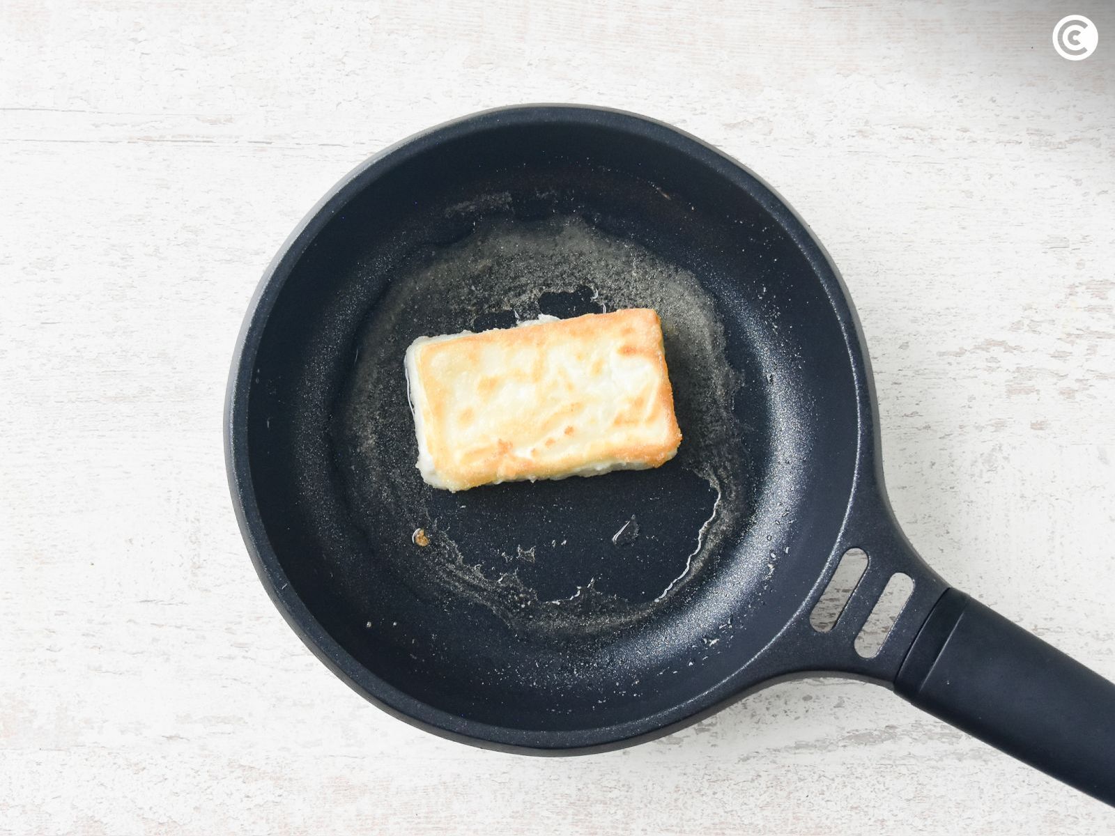 Freír el queso feta enharinado para hacer saganaki griego