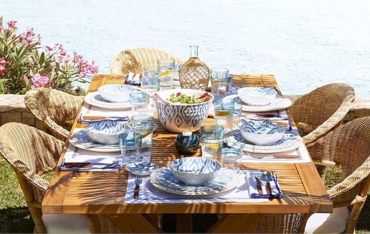 Mantel azul y vajilla blanca sobre mesa de madera maciza