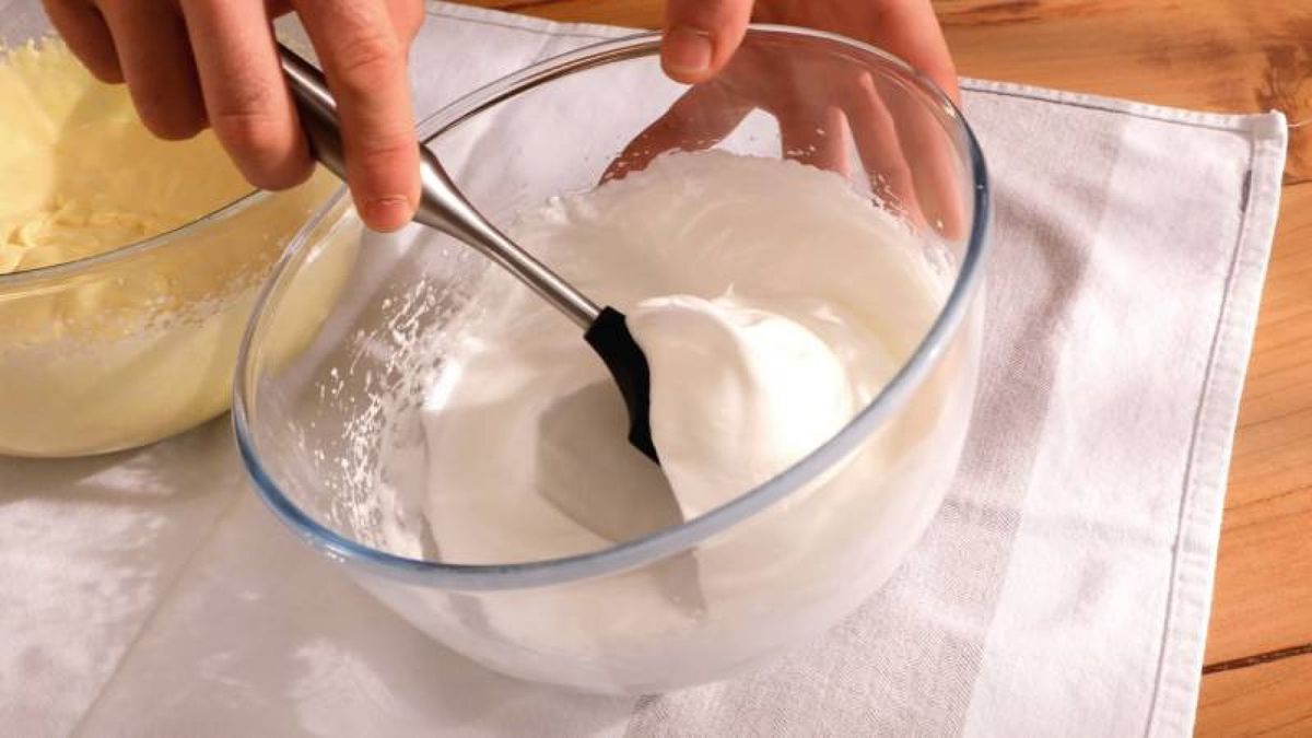 Añade las claras montadas a la mezcla de mascarpone y yemas, integrando suavemente para mantener la esponjosidad