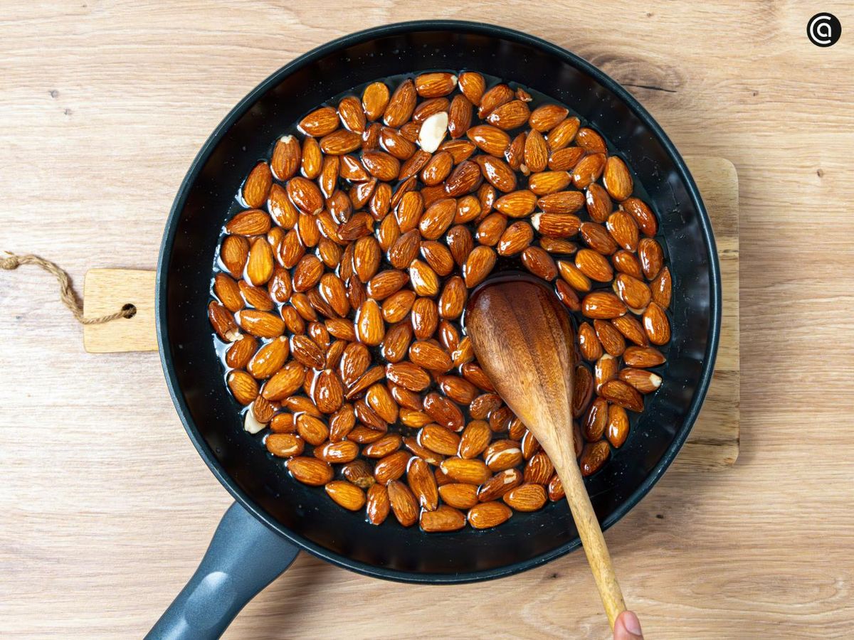 Agrega las almendras a la sartén y remueve para que se impregnen