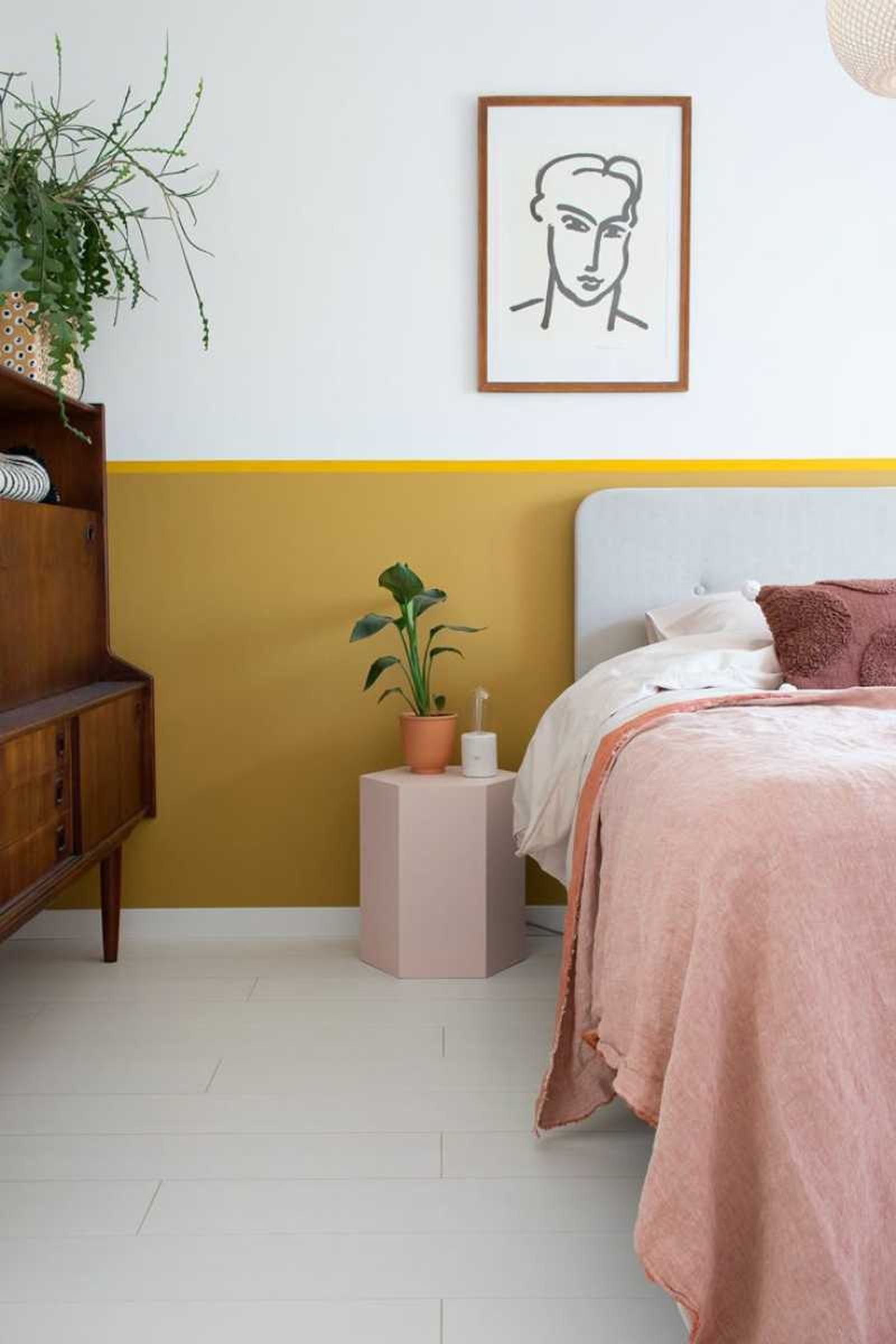 Dormitorio con pared con detalle en amarillo mostaza.