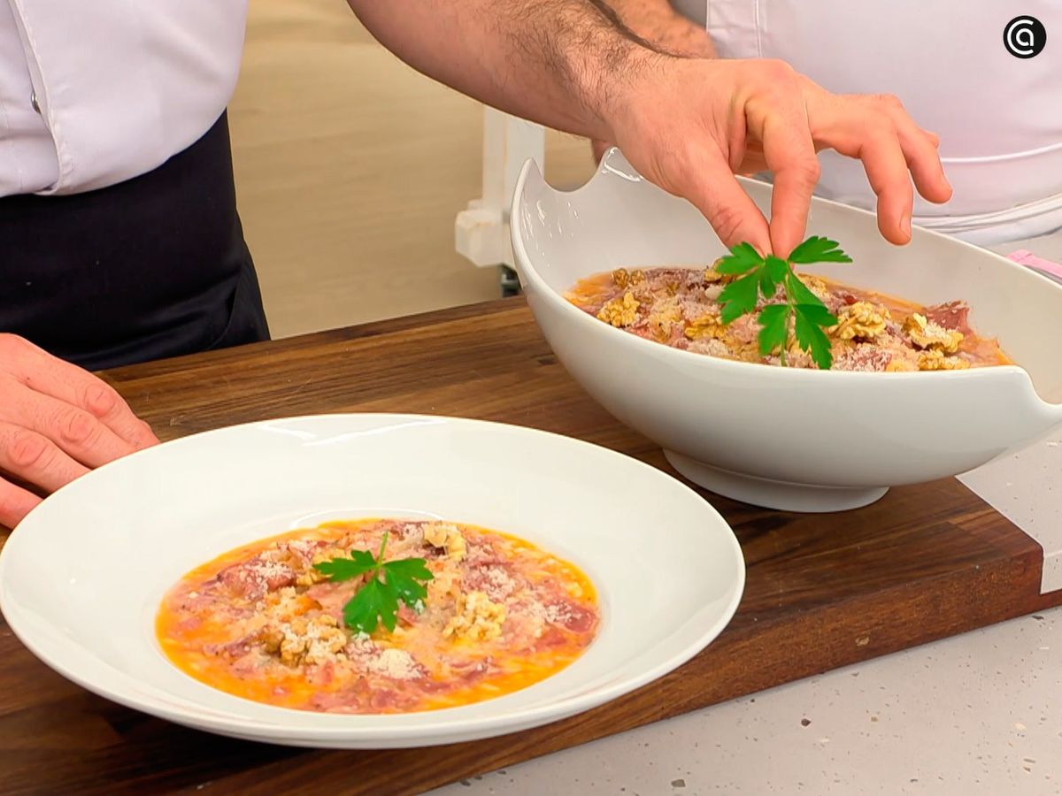 Termina el risotto de sobrasada con láminas de jabalí con nueces picadas y queso rallado