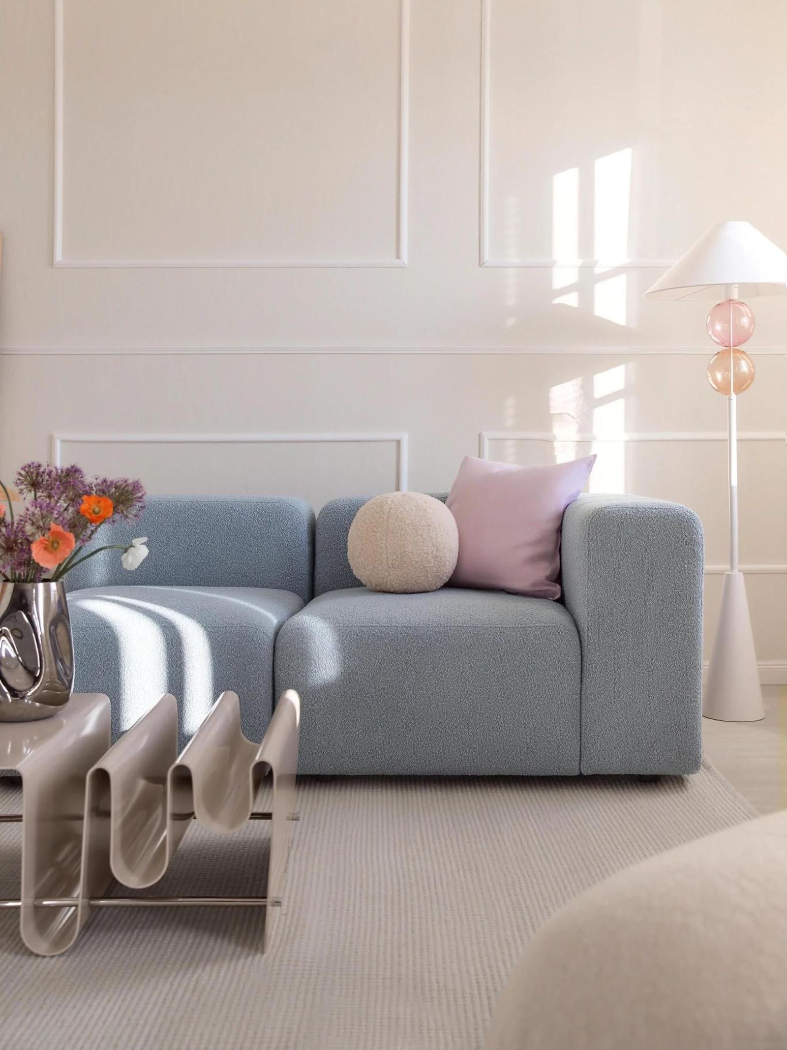 Salón primaveral con sofá azul y mesa moderna con forma ondulada. Salón primaveral con sofá azul y mesa moderna con forma ondulada.