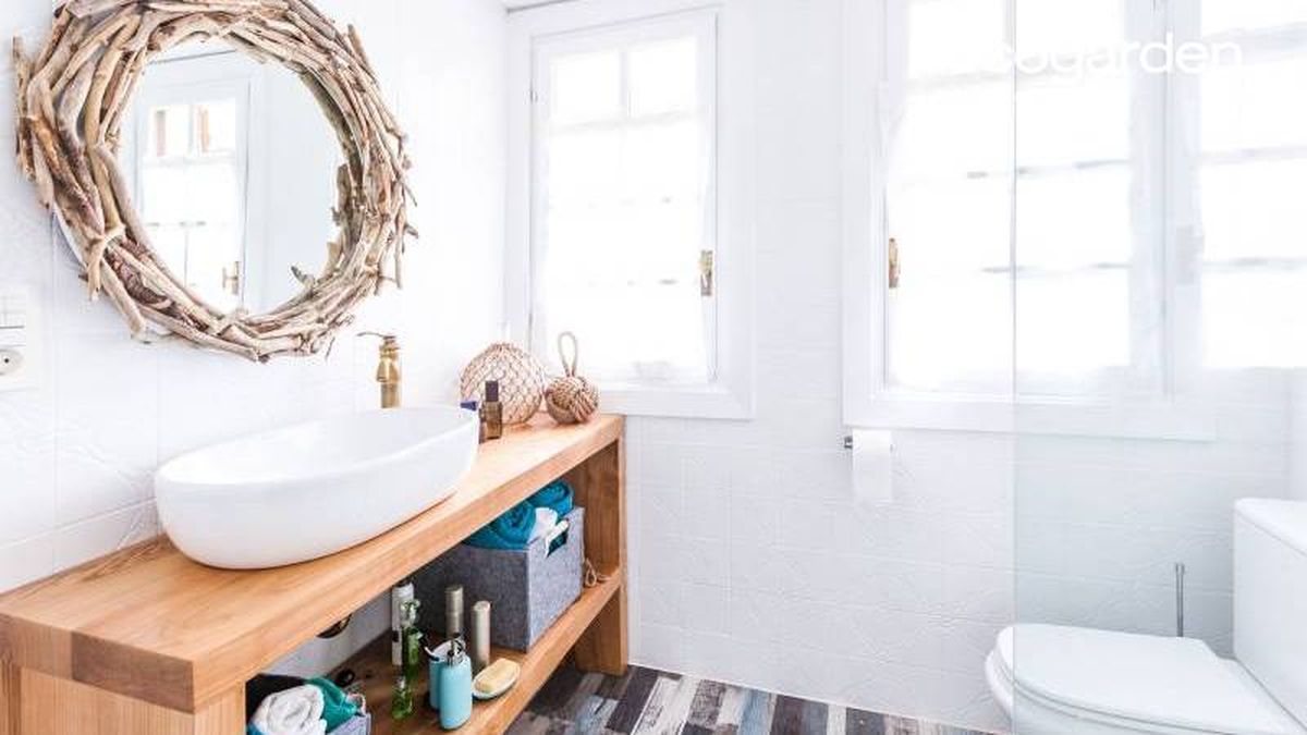 Espejo decorado con ramas en el cuarto de baño.