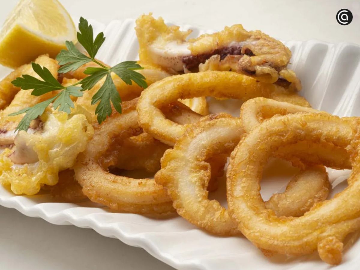 Calamares a la romana recién fritos, con un rebozado ligero y crujiente que invita a coger uno tras otro.