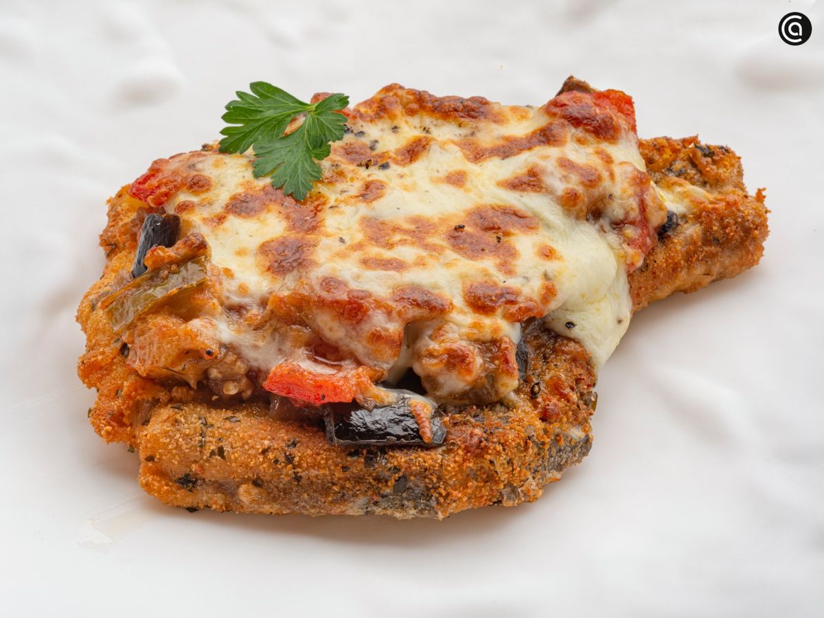 Milanesa de chuleta de cerdo con sanfaina gratinada
