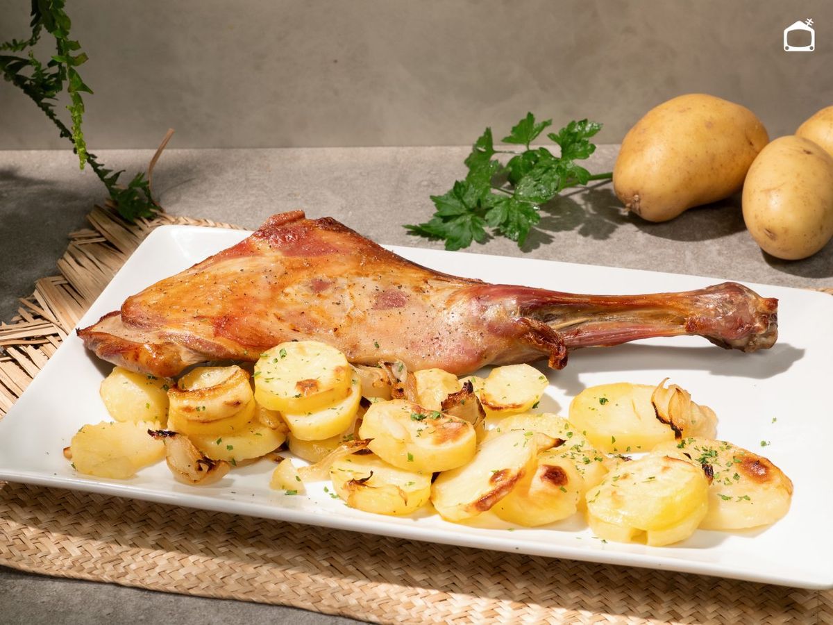 Espolvorea perejil picado sobre las patatas panadera y la paletilla de cordero al horno