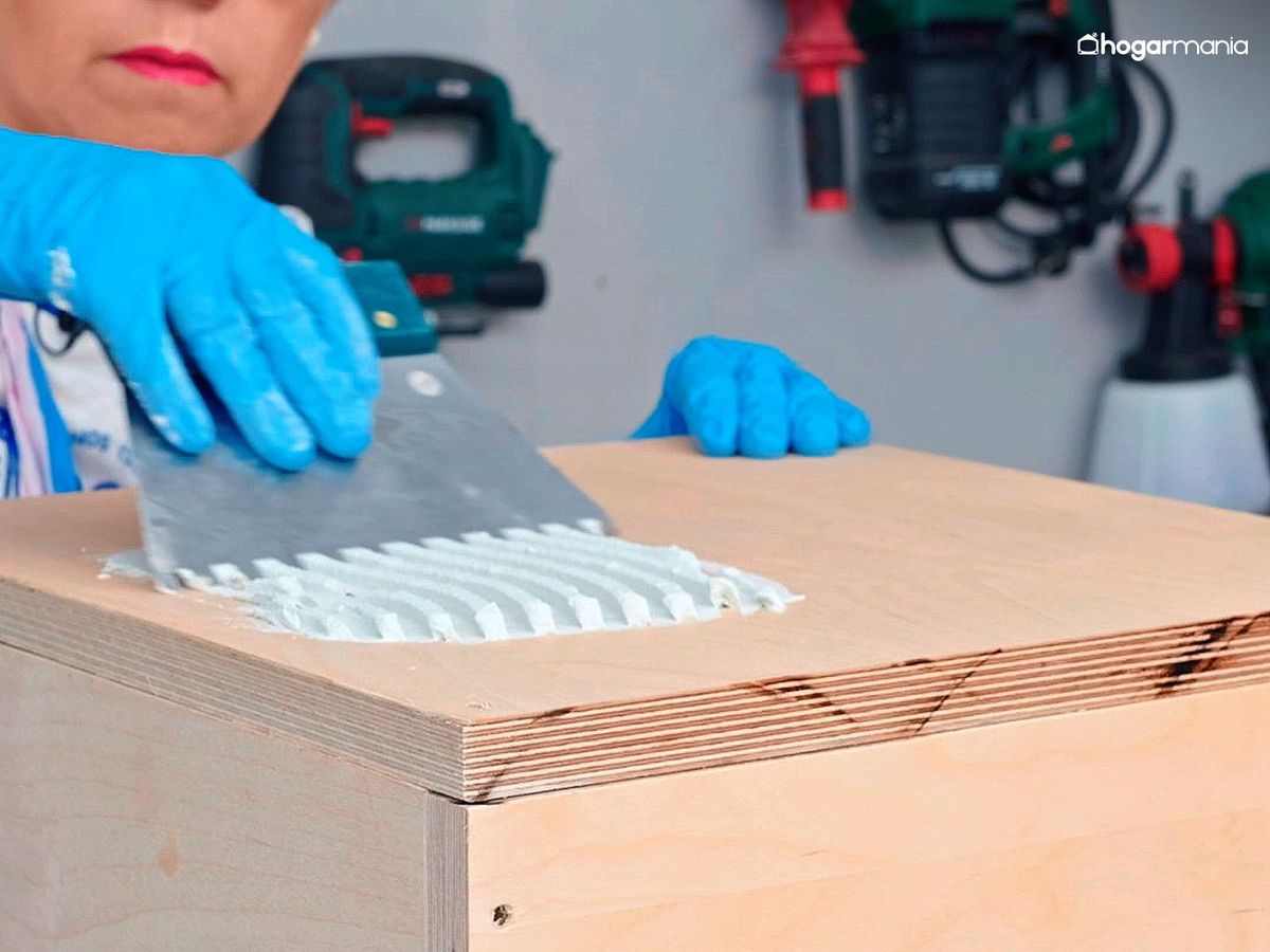 Extiende el cemento cola sobre la madera para fijar los azulejos de la mesa