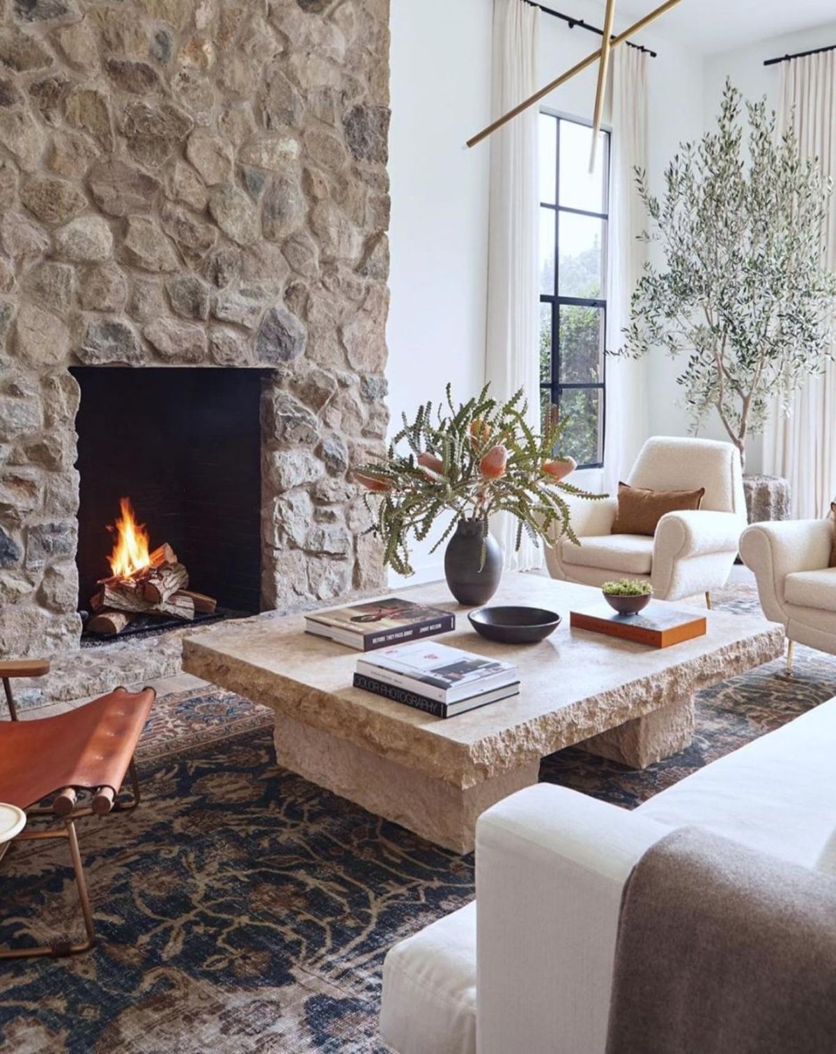 Salón con chimenea y mesa de piedra de estilo cabincore.