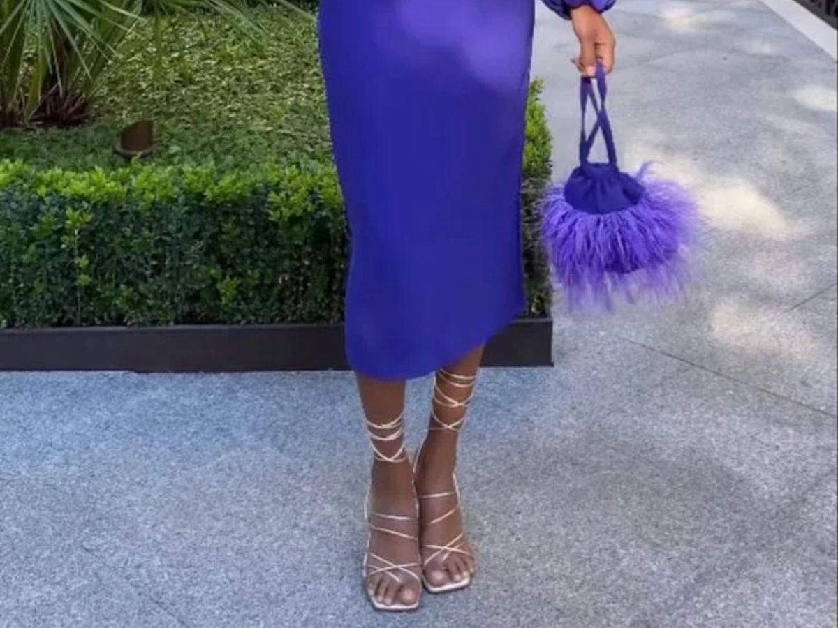 Bolso del color del vestido con sandalias doradas