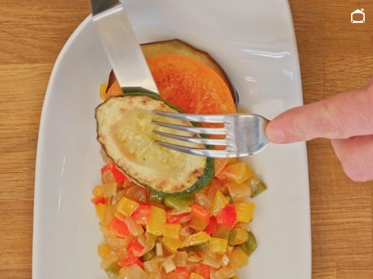 Las verduras se colocan alternadas y solapadas sobre el pisto, cuidando el orden y la presentación.