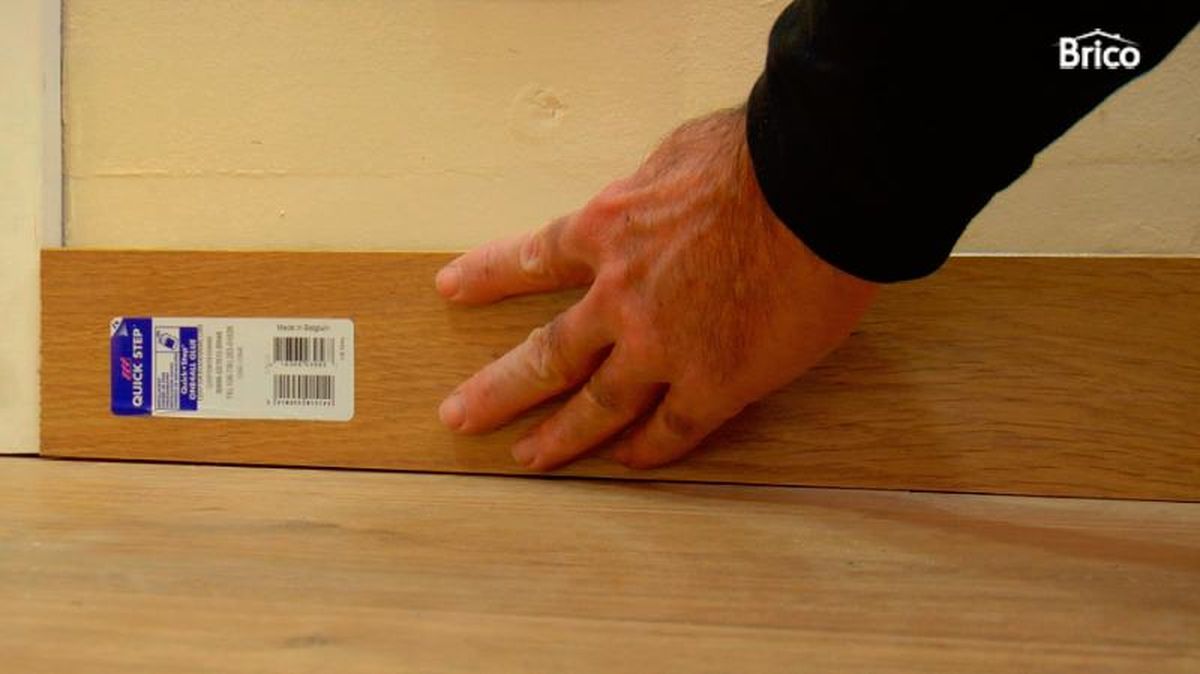 Persona colocando un zócalo de madera