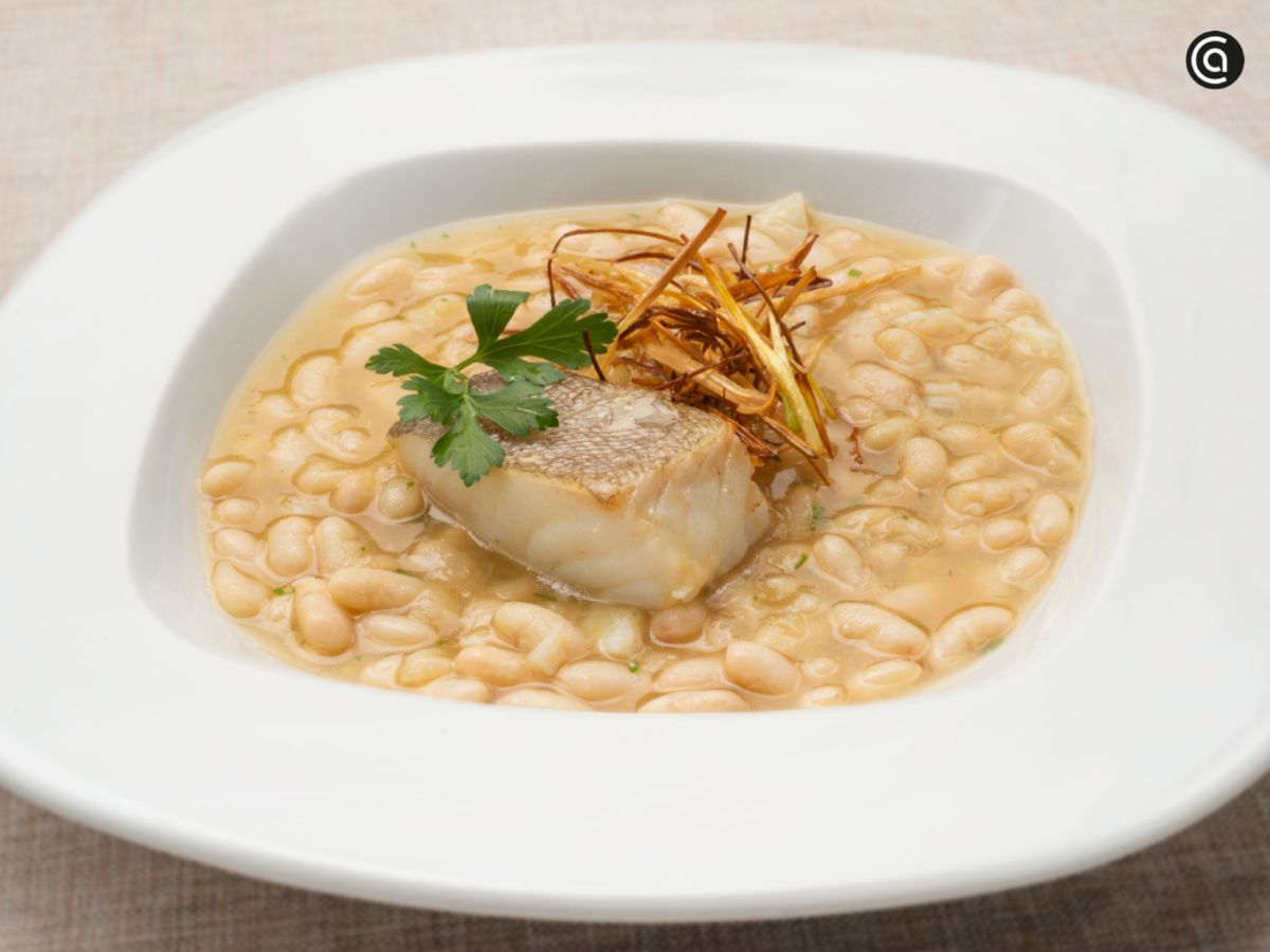 Pochas con bacalao confitado y puerro crujiente: un plato elegante que combina el sabor suave de las legumbres con el pescado.