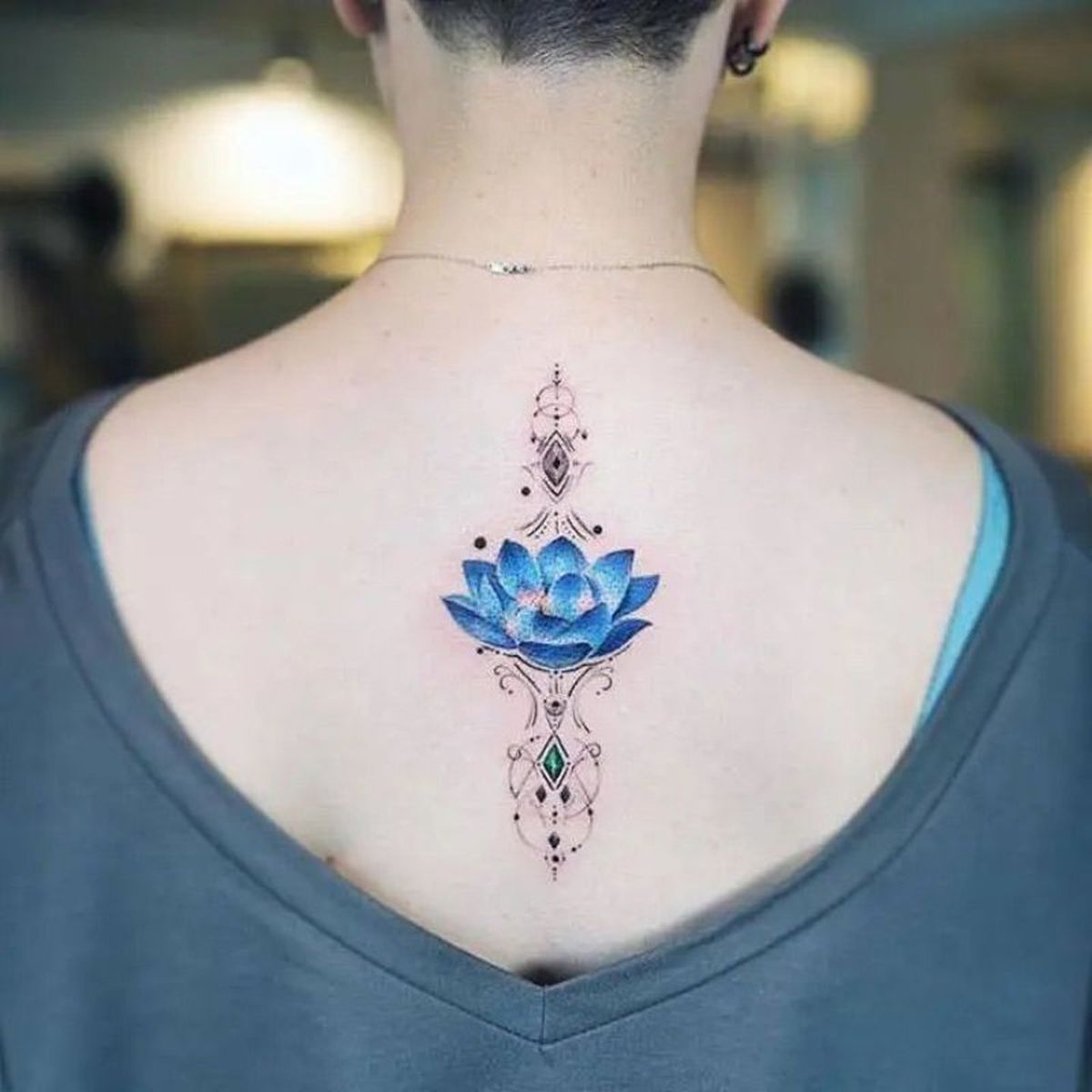 Tatuaje de una flor de loto en color azul