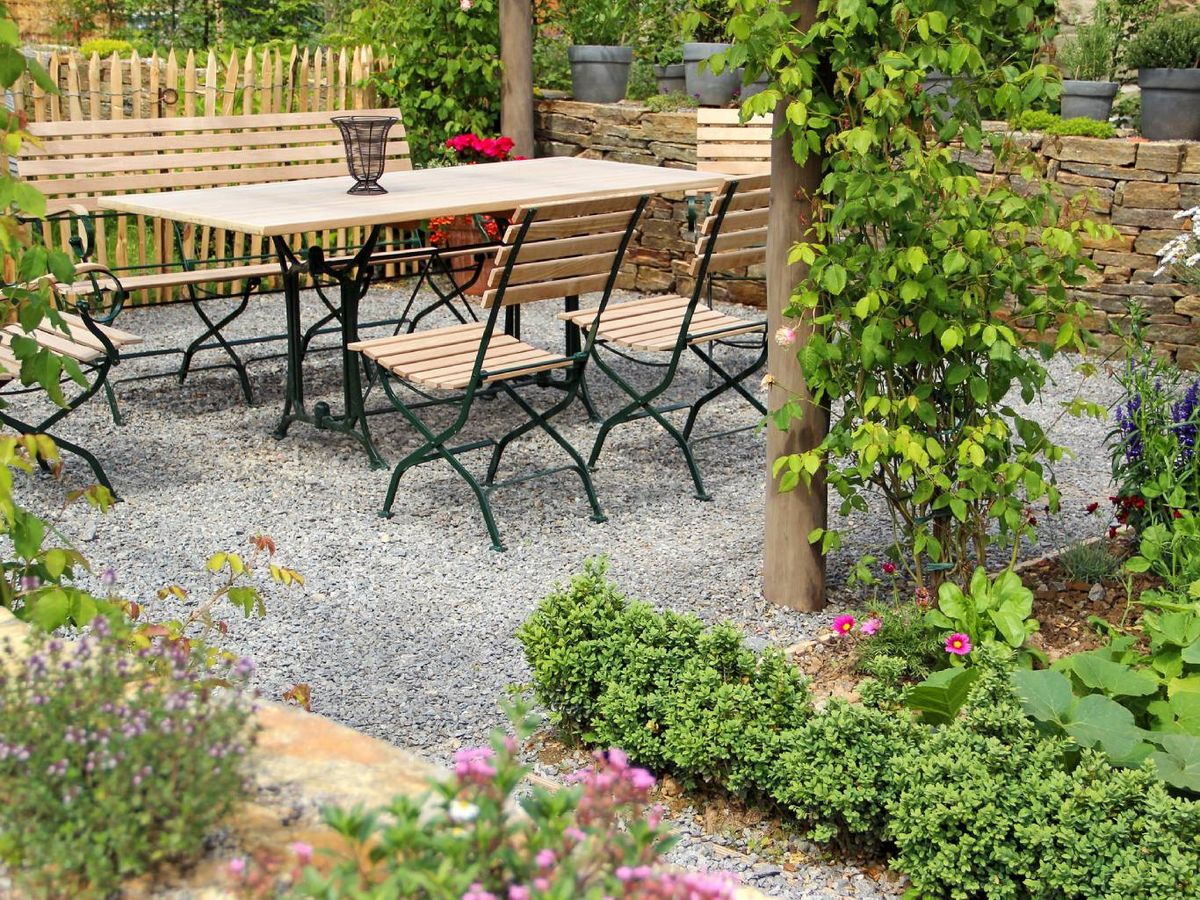 Jardín nórdico minimalista con muebles de exterior sencillos de madera y metal.