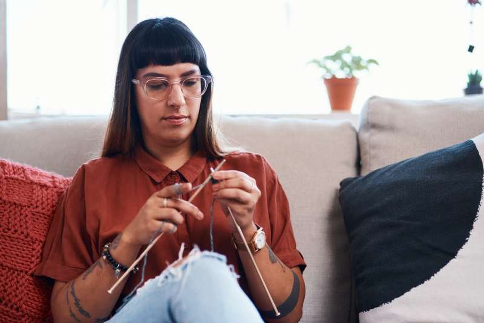 Mujer tejiendo con agujas de punto.