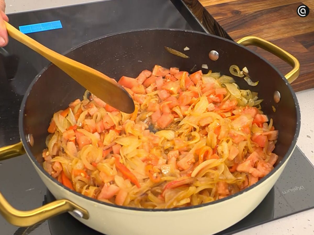 La cebolla en juliana y el pimiento rojo ya en la tartera, recién añadidos para comenzar el rehogado.