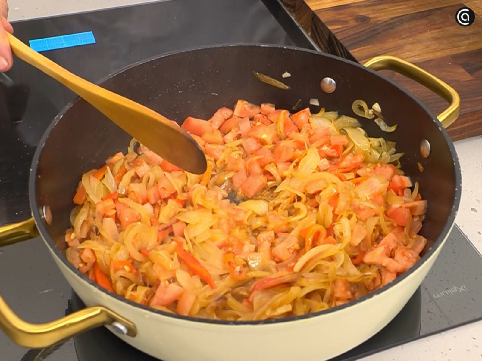 La cebolla en juliana y el pimiento rojo ya en la tartera, recién añadidos para comenzar el rehogado.