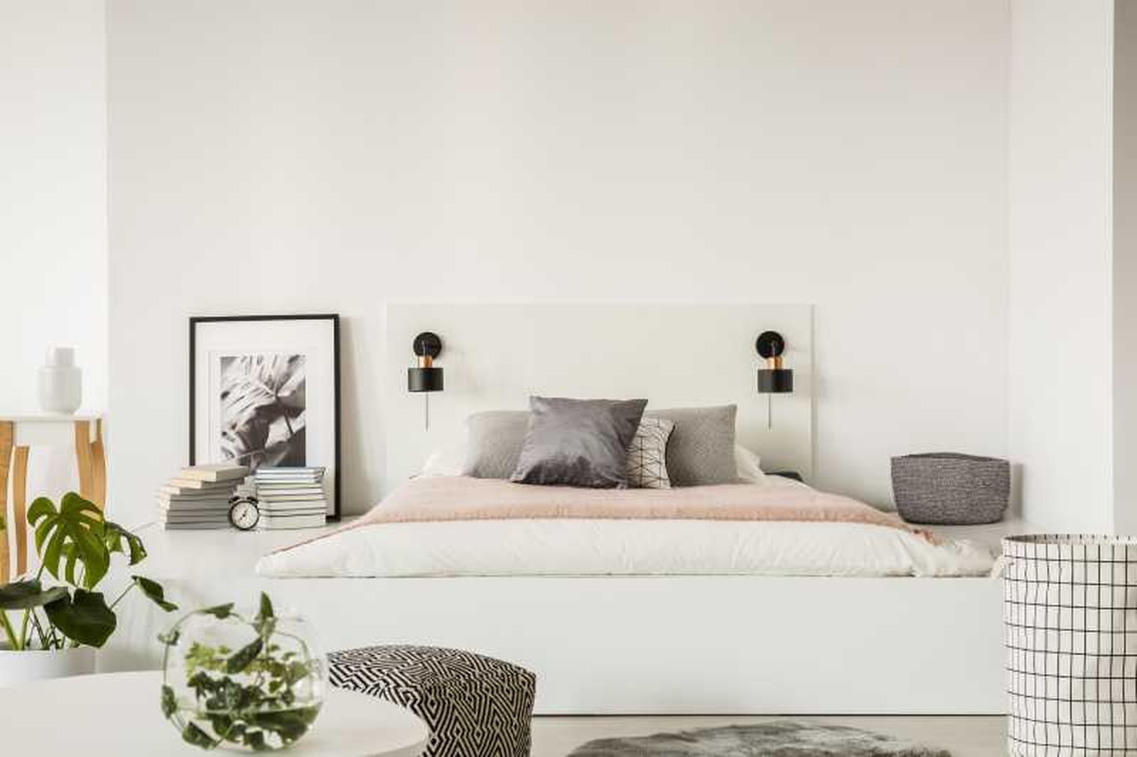 Dormitorio relajante en blanco y negro y decorado con plantas.