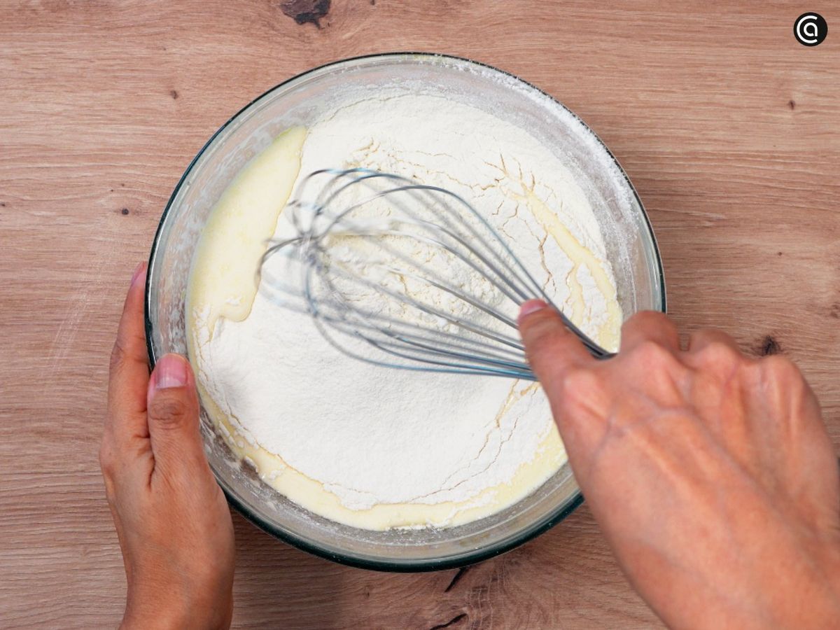 Incorpora la harina y levadura tamizada; remueve con varillas hasta que no queden grumos