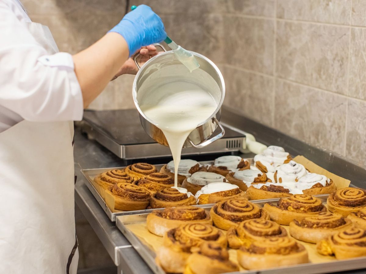 El rollo de canela americano se cubre con glaseado de crema