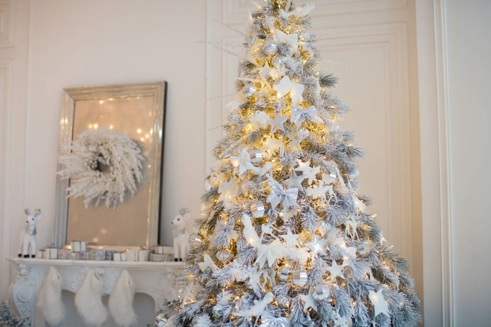Salón con árbol de Navidad y adornos en color blanco.